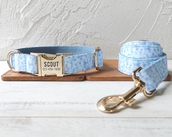 Peut inclure: Un collier et une laisse pour chien assortis, à motif bleu et blanc, avec une boucle en métal doré et une plaque de nom personnalisée indiquant "SCOUT 123-456-7890".