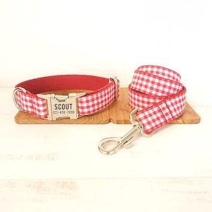 Può includere: Set di collare e guinzaglio per cani in gingham rosso e bianco con un'etichetta personalizzata argentata che recita "SCOUT 123-456-7890".