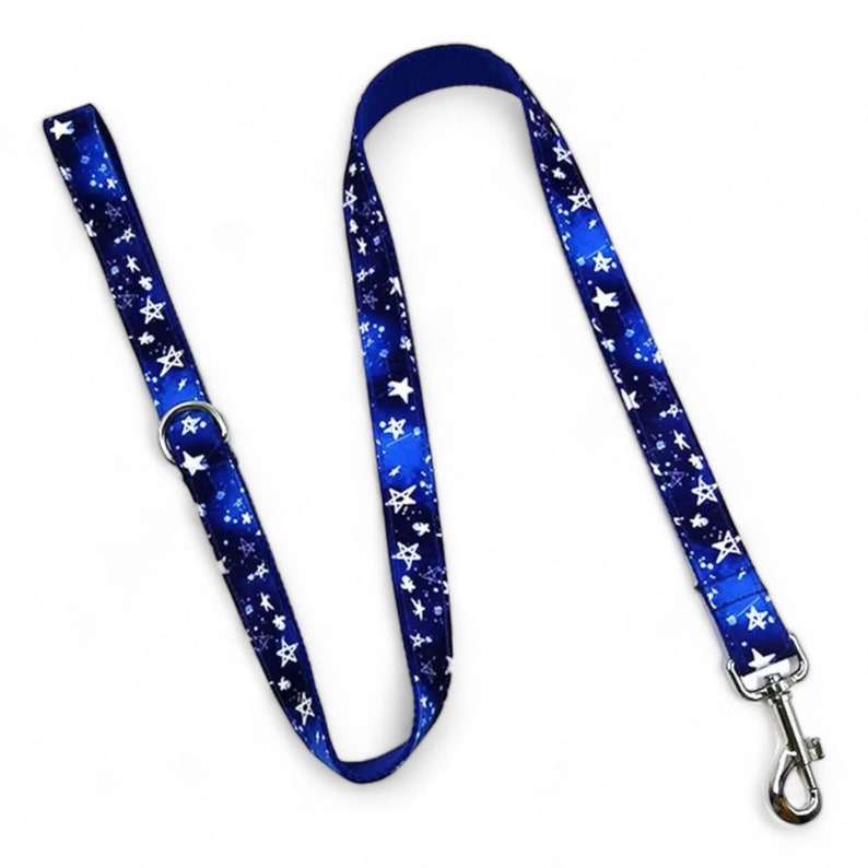 May include: A blue dog leash with a white star pattern. The leash has a silver clip and a silver ring.