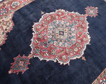May include: A dark blue rug with a large, intricate, red and white floral pattern in the center. The rug has a smaller, similar pattern in the corners.