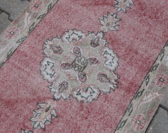 May include: A vintage pink and white runner rug with a floral pattern. The rug has a faded, distressed look and is perfect for adding a touch of bohemian style to your home.