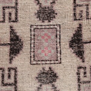 May include: Close-up of a beige rug with a geometric pattern in black and pink. The pattern features a central square with a smaller square inside, surrounded by four larger squares.