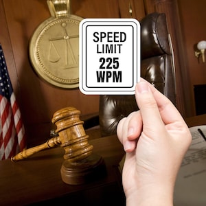 May include: A white rectangular sign with black text reading "SPEED LIMIT 225 WPM" is held in front of a courtroom setting. A wooden gavel and the American flag are visible in the background. The sign is held by a hand.