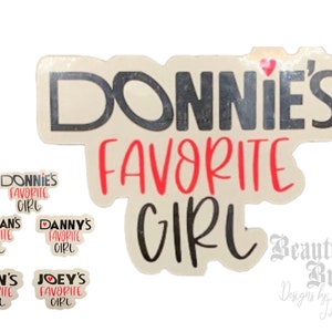 May include: A set of five stickers with the text "Donnie's Favorite Girl" in black and red lettering. The stickers are on a white background. The largest sticker has a heart at the top. The smaller stickers have different names in place of "Donnie's".