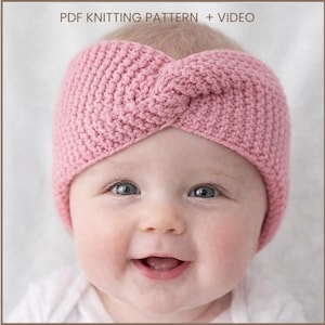 Puede incluir: Primer plano de un bebé con una diadema rosa tejida con un diseño de nudo retorcido. La diadema es de color liso. El bebé sonríe y tiene ojos azules. El texto "PDF KNITTING PATTERN + VIDEO" está en la parte superior.