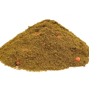 May include: A pile of brown ground spices with a few red peppercorns visible.
