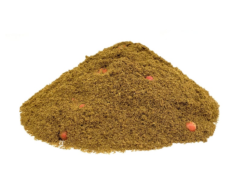 May include: A pile of brown ground spices with a few red peppercorns visible.