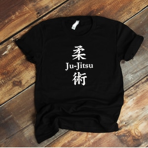 May include: Black t-shirt with white text that says "Ju-Jitsu" and has Japanese characters above and below the text.