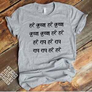 Puede incluir: Una camiseta gris con texto negro que dice "हरे कृष्ण हरे कृष्ण कृष्ण कृष्ण हरे हरे हरे राम हरे राम राम राम हरे हरे".