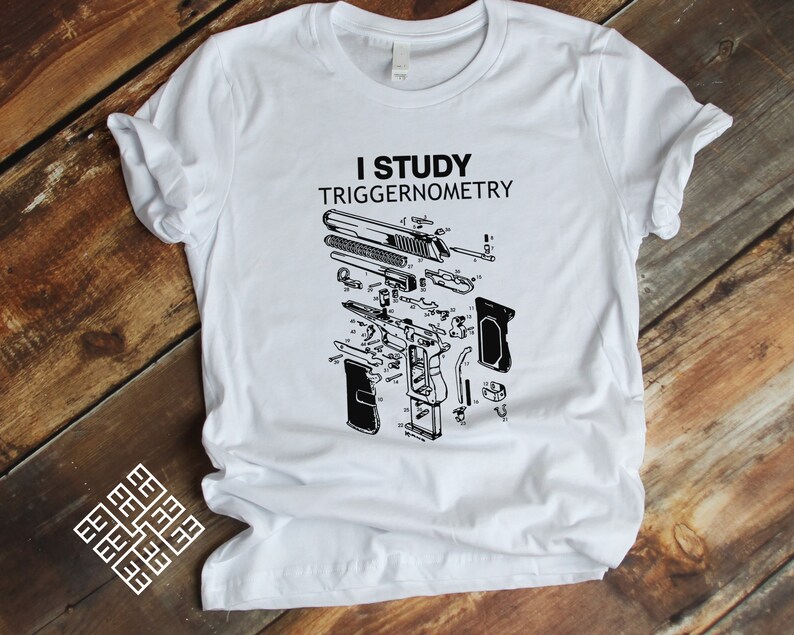 May include: White t-shirt featuring a black and white illustration of a disassembled handgun and the text "I study triggernometry".