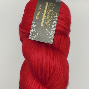 Może przedstawiać: Motka włóczki Cascade Yarns Magnum w kolorze Regal Red. Włóczka jest gruba i wykonana w 100% z superwash merino.