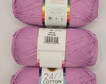 Könnte beinhalten: Drei Knäuel 24/7 Cotton Garn in der Farbe Orchid. Jedes Knäuel wiegt 100 g und enthält 170 m Garn. Das Garn besteht aus 100 % merzerisierter Baumwolle.