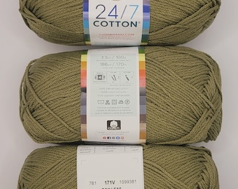 Könnte beinhalten: Drei Knäuel Lion Brand 24/7 Cotton Garn in der Farbe Buchtblatt. Das Garn ist mittelstark, 100% mercerisierte Baumwolle und maschinenwaschbar und trocknergeeignet. Die Knäuel sind mit dem Garngewicht, der Faserzusammensetzung, den Pflegehinweisen und dem Farbnamen gekennzeichnet.