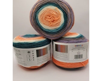 May include: Three balls of yarn in shades of orange, teal, white, and purple. The yarn is arranged in a pyramid shape. The yarn is labeled "Pegasus" and has a barcode.