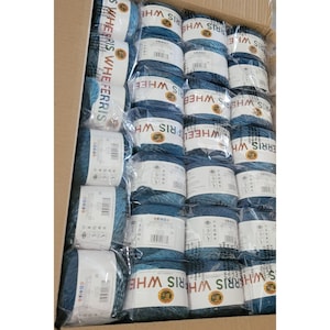 Puede incluir: Una caja llena de ovillos de lana azul y blanca. La lana está etiquetada como "Ferris Wheel" y "Wheel & Ferris".