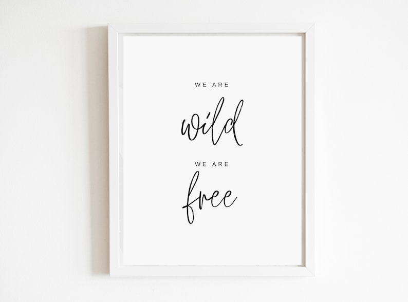 May include: White framed print with black calligraphy that reads "We are wild, We are free".