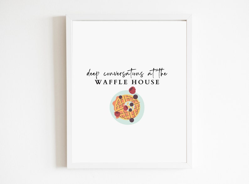 May include: A white framed print with the text "deep conversations at the WAFFLE HOUSE" and a cartoon illustration of a waffle with blueberries and raspberries on a blue plate.