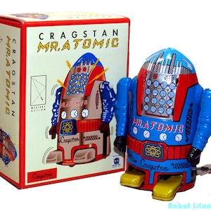 May include: A vintage wind-up toy robot named "Mr. Atomic" by Cragstan, with its original box. The robot is primarily blue, red, and brown with yellow feet. The box features the robot's image and the text "Mr. Atomic".