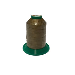 Puede incluir: Una bobina de hilo metálico dorado en un carrete de plástico verde.