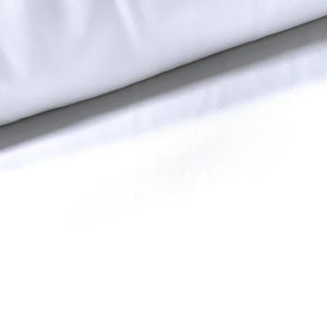Könnte beinhalten: Weißer Stoff mit einer glatten, gleichmäßigen Textur. Der Stoff ist über sich selbst gefaltet und bildet eine weiche, sanfte Kurve.