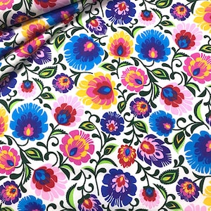Può includere: Tessuto bianco con un motivo ripetitivo di fiori colorati. I fiori sono in tonalità di rosso, rosa, giallo, blu e viola. Il tessuto ha uno stile tradizionale di arte popolare.