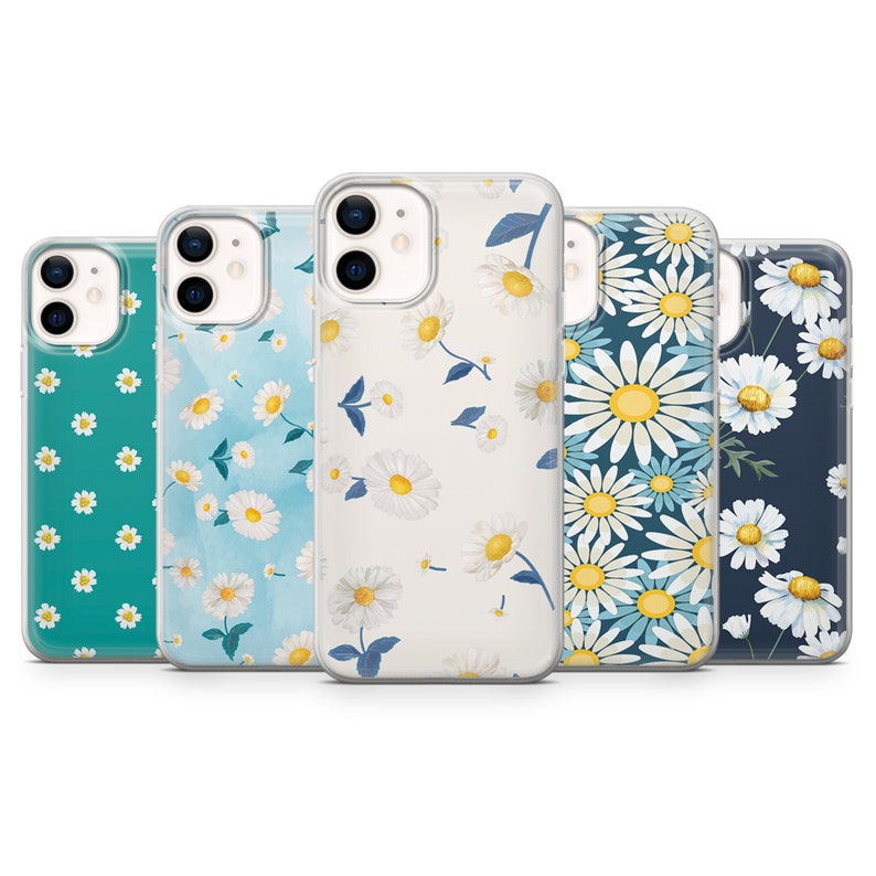 May include: Five phone cases with daisy floral patterns. The cases feature a variety of backgrounds, including teal, light blue, white, and navy. The daisies have white petals and yellow centers. The cases are designed to fit a smartphone.