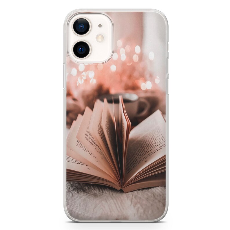 May include: An open book with pages fanned out, resting on a soft, white surface. The book is illuminated by warm, soft light, creating a cozy and inviting atmosphere.
