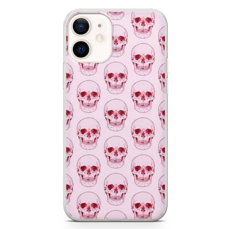 May include: A clear phone case with a pink background and a repeating pattern of red skulls.