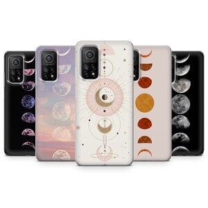 May include: Set of four phone cases featuring different moon phases designs. The cases are clear with a white background and feature gold accents. The designs include a crescent moon, a half moon, a full moon, and a moon with stars.