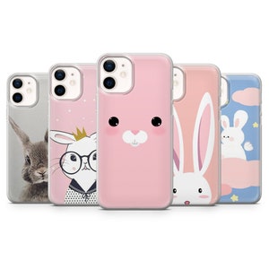 Puede incluir: Cuatro fundas de tel&eacute;fono diferentes con dise&ntilde;os de conejos lindos. Las fundas son transparentes y muestran la lente de la c&aacute;mara del tel&eacute;fono. Los dise&ntilde;os de conejos son rosas, blancos y grises.