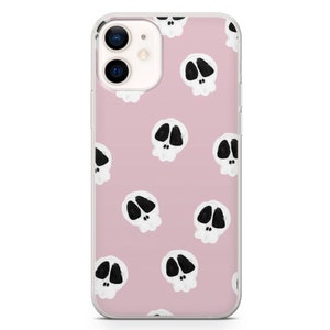 May include: A clear phone case with a pink background and a repeating pattern of white skulls with black eyes.