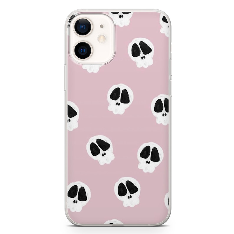 May include: A clear phone case with a pink background and a repeating pattern of white skulls with black eyes.