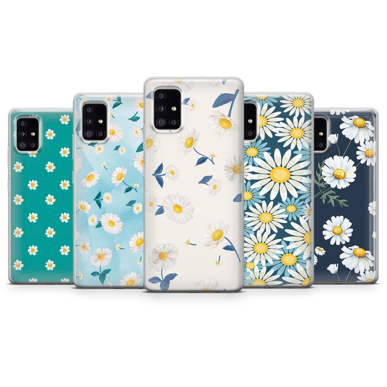 May include: Five phone cases with daisy floral designs. The cases feature white daisies with yellow centers and green leaves on various backgrounds, including teal, light blue, and navy. The cases are made of clear plastic.