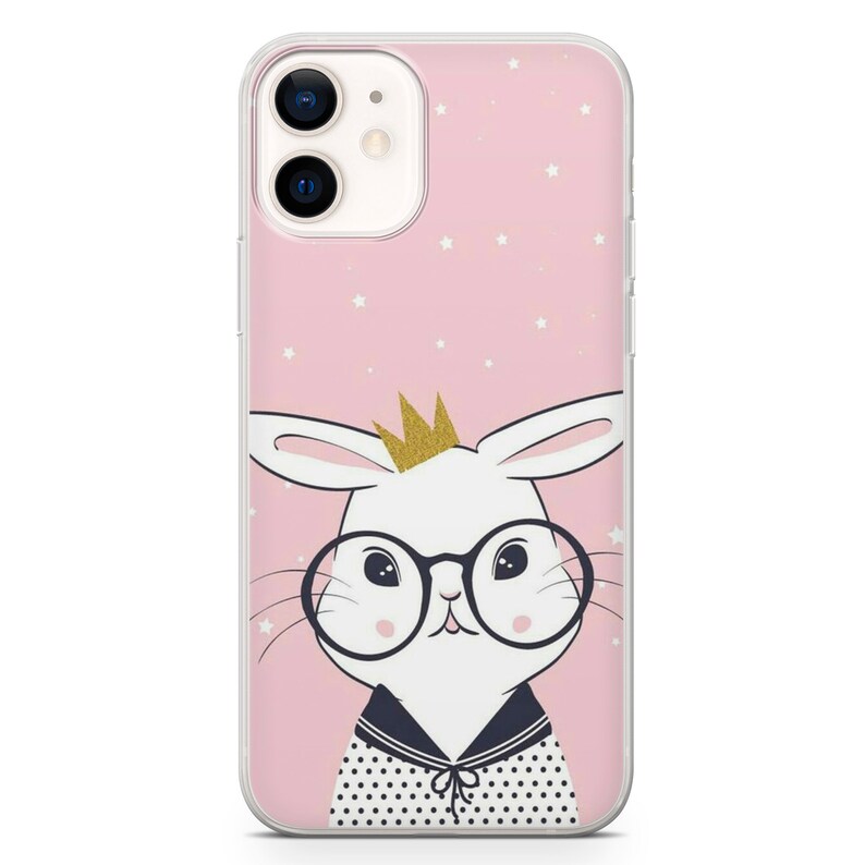 Puede incluir: Una funda de tel&eacute;fono rosa con un conejo blanco que lleva gafas y una corona dorada. El fondo es rosa con estrellas blancas.