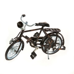 May include: A brown metal toy bicycle with a black seat and a bell on the handlebars.
