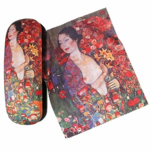 Pode incluir: Uma caixa retangular para óculos com um padrão floral colorido que apresenta uma mulher com um vestido vermelho e azul. A caixa é feita de um material macio e tem um fecho de correr.