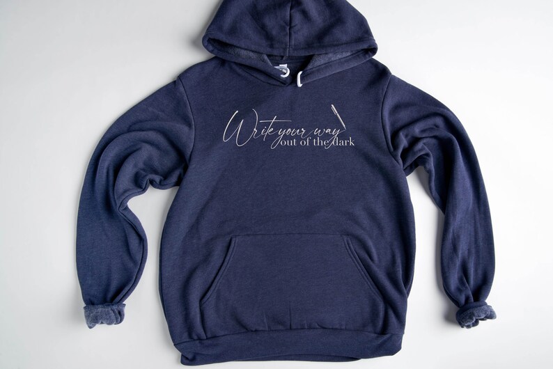 May include: A navy blue hoodie with a white graphic that says "Write your way out of the dark".