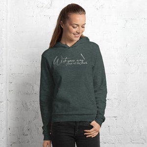 May include: A dark green hooded sweatshirt with the text "Write your way out of the dark" in white cursive lettering.