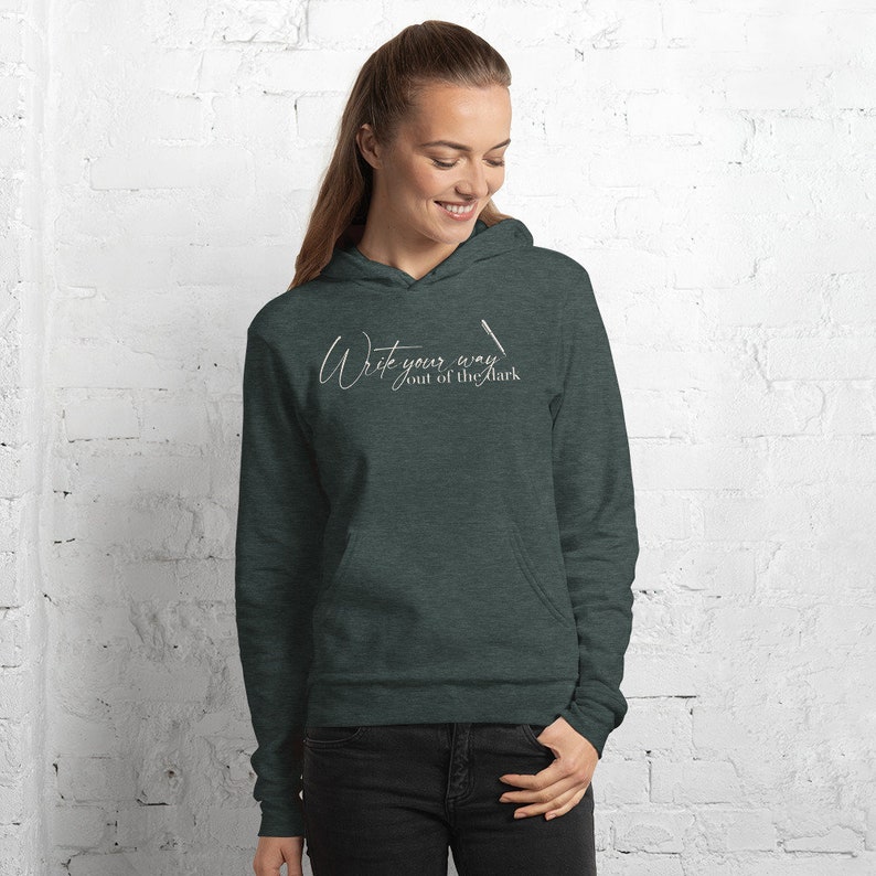 May include: A dark green hooded sweatshirt with the text "Write your way out of the dark" in white cursive lettering.