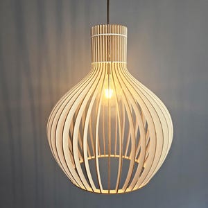 May include: A wooden pendant light fixture with a round, cage-like design. The light is made of thin, vertical slats of wood that create a geometric pattern.