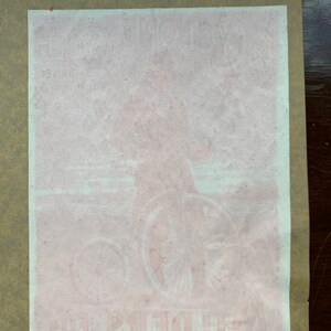 Puede incluir: Un anuncio vintage descolorido en rosa y blanco para una bicicleta con el texto "The Monarch" y "Bates, Columbia" visible.