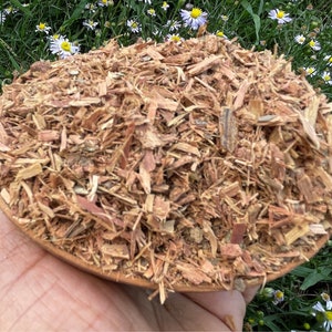 K&ouml;nnte beinhalten: Nahaufnahme eines Haufens getrockneter, zerkleinerter Rinde in einer Holzschale. Die Rinde ist hellbraun und hat eine raue Textur.