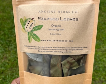 May include: A brown paper bag with a clear window showing dried soursop leaves. The bag is labeled "Ancient Herbs Co. Soursop Leaves Organic Jamaica grown 0.5 oz/14 g WWW.ANCIENTHERBSCO.COM". The bag also includes instructions for brewing tea.