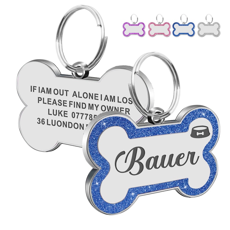 May include: A silver bone-shaped dog tag with blue glitter trim. The tag has the text "IF I AM OUT ALONE I AM LOST PLEASE FIND MY OWNER LUKE 077785 36 LUONDON" on one side and the name "Bauer" on the other side. The tag comes with a silver ring.