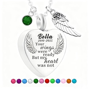 May include: A silver heart-shaped pendant necklace with the inscription "Bella 2010-2025 Your wings were ready But my heart was not." The necklace includes a green gemstone and a rose with a wing charm.