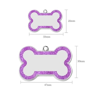 May include: Two silver bone-shaped dog tags with a purple glitter finish. The smaller tag is 1.3 inches wide and 0.8 inches tall. The larger tag is 1.9 inches wide and 1.2 inches tall.