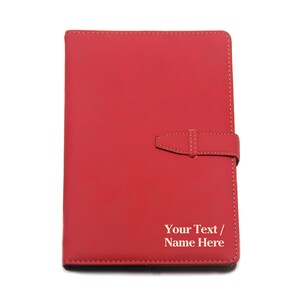 May include: Red leather journal with a strap closure and the text "Your Text / Name Here" embossed in white.