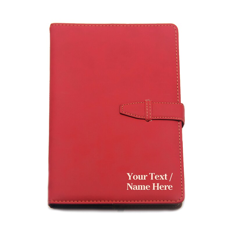 May include: Red leather journal with a strap closure and the text "Your Text / Name Here" embossed in white.