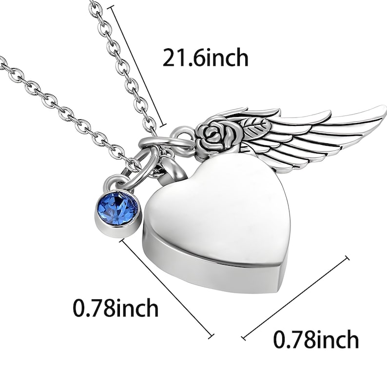 May include: A silver-colored heart-shaped pendant necklace with a blue gemstone charm. The pendant has a wing and rose design. The chain is 21.6 inches long, and the pendant is 0.78 inches wide.