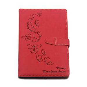 Peut inclure: Journal en cuir rouge avec un motif de papillon et le texte "Vivian Love from Irene" grav&eacute; sur le devant.